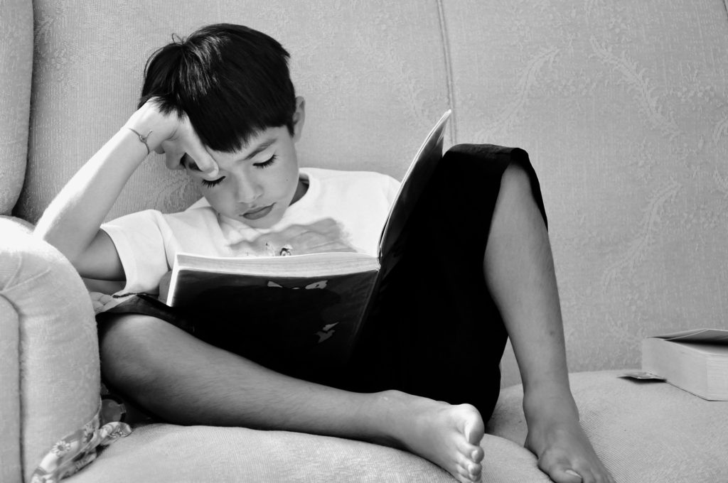 Boy sitting on a sofa, reading