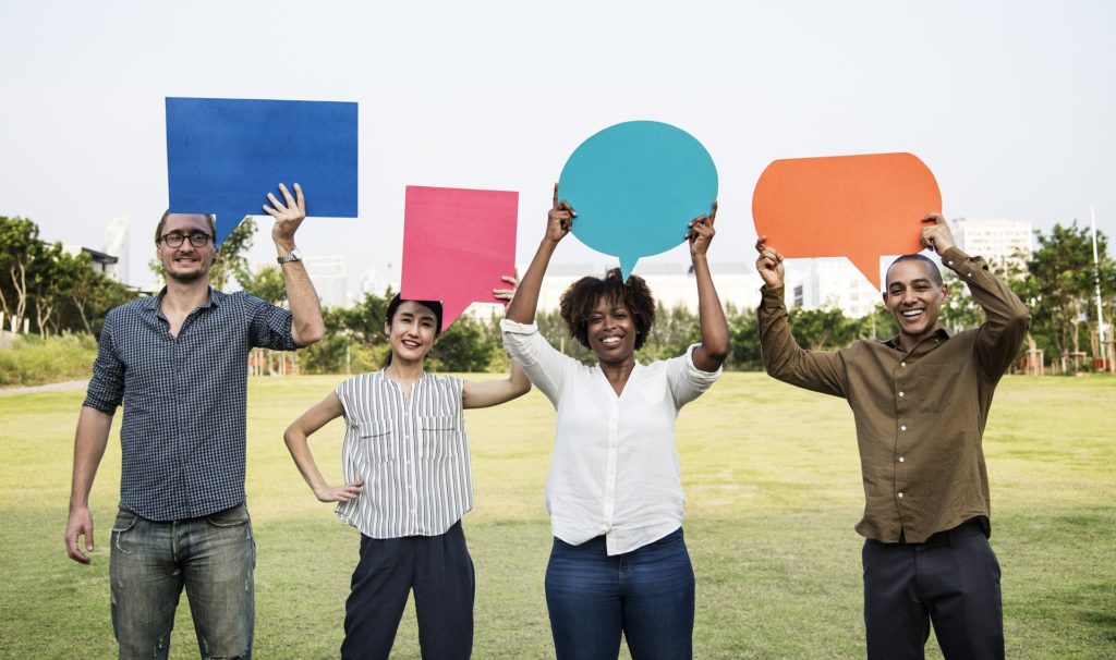 Four people holding speech bubbles