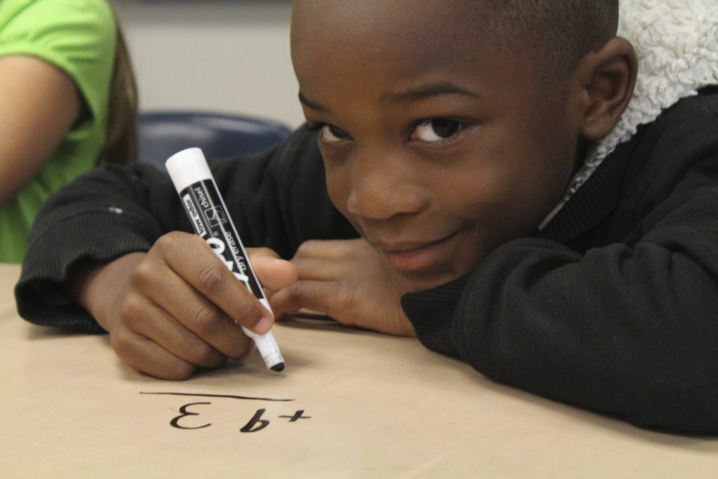 Smiling boy doing maths work