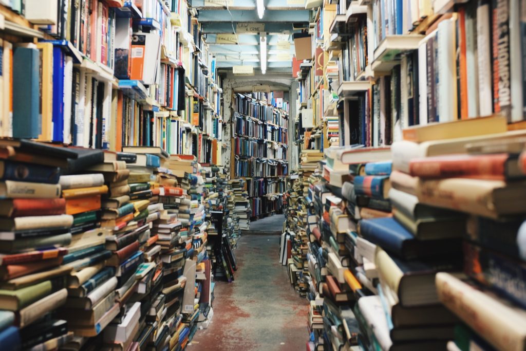 Crowded library shelves and books on the floor