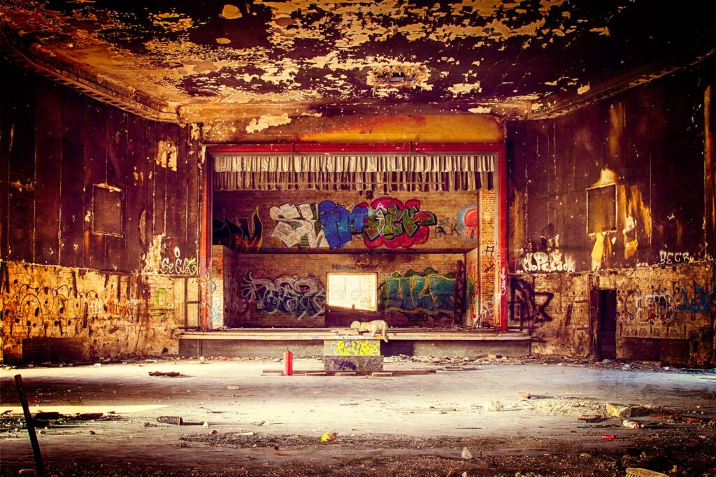 Abandoned theatre with peeling walls and graffiti